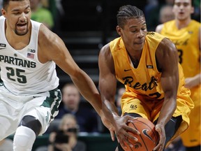 Michigan State's Kenny Goins, left, reaches in against Long Beach State's LaRond Williams during the first half of an NCAA college basketball game, Thursday, Dec. 21, 2017, in East Lansing, Mich.