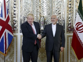 Iranian Foreign Minister Mohammad Javad Zarif, right, and his British counterpart Boris Johnson, shake hands as they pose for media prior to their talks in Tehran, Iran, Saturday, Dec. 9, 2017.  Johnson arrived in Tehran on Saturday, where he is expected to discuss the fate of detained British-Iranian woman Nazanin Zaghari-Ratcliffe, who is serving a five-year prison sentence for allegedly plotting to overthrow Iran's government.
