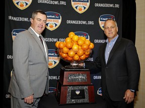 Wisconsin head coach Paul Chryst, left, and Miami head coach Mark Richt stand with the Orange Bowl trophy at an NCAA college football news conference in Fort Lauderdale, Fla., Friday, Dec. 29, 2017. The teams will meet in the Orange Bowl on Saturday, Dec. 30.