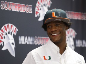 Daquris Wiggins wears a Miami Hurricanes hat after signing with the NCAA college football team at Miami Southridge High in Miami, Fla., Wednesday, Dec. 20, 2017.