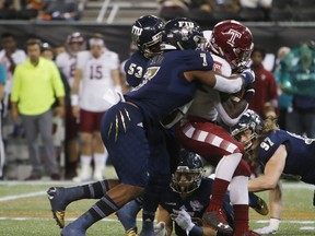 Temple running back David Hood (24) is tackled by Florida International defensive lineman Fermin Silva (7) during the first half of the Gasparilla Bowl NCAA college football game Thursday, Dec. 21, 2017, in St. Petersburg, Fla.
