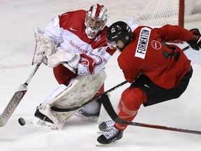 Team Denmark goaltender Emil Gransoe shoots the puck away from Team Canada's Alex Formenton on Dec. 15, 2017