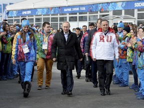 FILE - In this Feb. 5, 2014 file photo Russian President Vladimir Putin, center, visits the Olympic Athletes Village in Coastal Cluster ahead of the Sochi 2014 Winter Olympics with Olympic Village Mayor Elena Isinbaeva, left, and Russian Minister of Sport, Tourism and Youth policy Vitaly Mutko in Sochi, Russia. Russia could be banned from competing at the Pyeongchang Olympics. The decision will come on Tuesday, Dec. 5, 2017 when the International Olympic Committee executive board meets in Lausanne, less than nine weeks before the games open on Feb. 9 in South Korea.