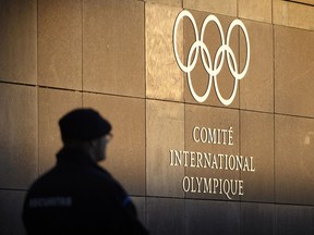 A private security personnel guards the entrance of the International Olympic Committee (IOC) headquarters in front of the Olympic Rings prior to the opening of the first day of the executive board meeting of the International Olympic Committee (IOC) at the IOC headquarters, in Pully near Lausanne, on Tuesday, Dec. 5, 2017. The IOC executive board is meeting to decide if Russian athletes can compete at the upcoming Pyeongchang Olympics despite evidence that the country ran an orchestrated doping program at the 2014 Sochi Games.