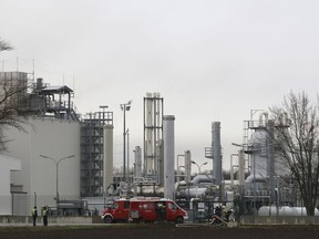 Firefighters stand outside a gas plant after an explosion occured near Baumgarten an der March, Austria, Tuesday, Dec. 12, 2017. At least one person was killed and several were injured in the blast.