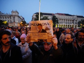 FILE - In this Oct. 8, 2016 file picture a man shows the last printed edition of Nepszabadsag during a demonstration organized to express solidarity with Hungarian political daily Nepszabadsag in Budapest, Hungary, Prime Minister Viktor Orban's government and supportive media leave limited opportunities for opposition parties to get their message out. The main independent newspaper, Nepszabadsag, closed last year under political pressure, and most surviving media groups are now controlled by allies of Orban, who will be seeking a fourth term next year.