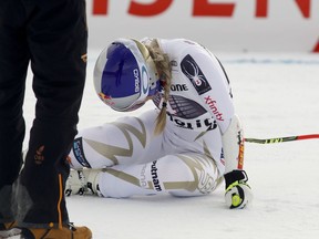 United States' Lindsey Vonn lies on the snow in pain after getting to the finish area after completing an alpine ski, women's World Cup super-G, in St. Moritz, Switzerland, Saturday, Dec. 9, 2017.