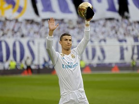 Real Madrid's Cristiano Ronaldo holds up one of his five Golden Ball trophy prior the Spanish La Liga soccer match between Real Madrid and Sevilla at the Santiago Bernabeu stadium in Madrid, Saturday, Dec. 9, 2017.