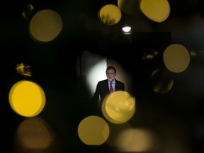 Spain's Prime Minister Mariano Rajoy, seen through a Christmas tree, talks to journalists during a news conference following to the last Cabinet meeting of the year at the Moncloa palace in Madrid, Friday, Dec. 29, 2017. Rajoy said he intends calling the first session for the new parliament of Spain's restive region of Catalonia on Jan. 17.