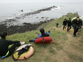 FILE  - In this April 21, 2007 file photo, abalone divers rest, left, after making a climb up a cliff in Fort Ross, Calif. California wildlife officials have voted to cancel the 2018 abalone fishing season due to concerns about mass starvation among the mollusks along Sonoma and Mendocino coasts. The Santa Rosa Press Democrat reports the state Fish and Game Commission voted 4-0 Thursday, Dec. 7 during a public meeting in San Diego.