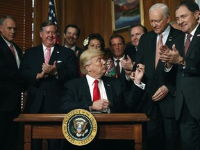 FILE - In this April, 26, 2017, file photo, President Donald Trump hands a pen to Sen. Orrin Hatch, R-Utah after signing an Antiquities Executive Order during a ceremony at the Interior Department in Washington. Utah has long stood out for going far beyond other Western states in trying to get back control of its federally protected lands. When President Donald Trump on Monday, Dec. 4, 2017, announces he's going to shrink two national monuments in the state, his warm welcome will stand out in a region that is normally protective of its parks and monuments.