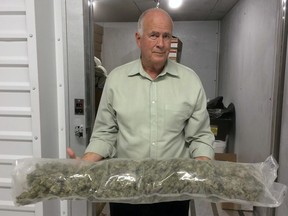 In this photo taken Nov. 28, 2017, Brad Eckenweiler,  chief executive of Lifestyle Delivery Systems, poses for a photo while holding cannabis buds from his freezer that will be used to manufacture concentrates in Adelanto, Calif. Lifestyle is what's known as a "vertically integrated company," with a hand in every aspect of the business, from producing organic seeds to transportation and over-the-counter sales.
