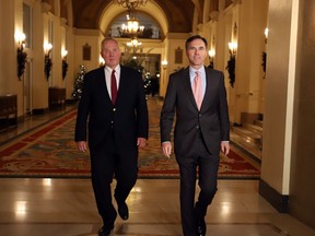Federal Finance Minister Bill Morneau, right, and Parliamentary Secretary to the Minister of Justice Bill Blair make their way to talk to reporters before joining their federal, provincial and territorial counterparts for dinner in Ottawa, Sunday, December 10, 2017.