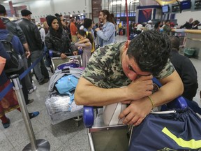 Alexis Canete rests on his luggage as he waits in the Delta ticket line to get back home to Cuba from his visit to Tennessee on Monday Dec. 18, 2017 at Hartsfield-Jackson International Airport in Atlanta, the day after a massive power outage brought operations to halt. Power was restored at the world's busiest airport after a massive outage Sunday afternoon that left planes and passengers stranded for hours, forced airlines to cancel more than 1,100 flights and created a logistical nightmare during the already-busy holiday travel season.