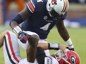 FILE - In this Nov. 11, 2017, file photo, Auburn linebacker Jeff Holand tackles Georgia quarterback Jake Fromm, breaking up a play during the first half of an NCAA college football game, in Auburn, Ala. Three weeks after an ugly loss at Auburn, No. 6 Georgia has perhaps the biggest do-over in school history. At stake will be the Southeastern Conference championship and a probable spot in the College Football Playoff. (Curtis Compton/Atlanta Journal-Constitution via AP, File)