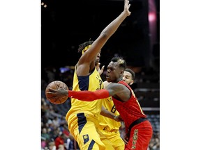 Atlanta Hawks' Dennis Schroder, right, of Germany, passes the ball behind the back of Indiana Pacers' Myles Turner in the first quarter of an NBA basketball game in Atlanta, Wednesday, Dec. 20, 2017.