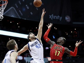 Atlanta Hawks' Dennis Schroder, right, of Germany, shoots over Dallas Mavericks' Maximilian Kleber, also of Germany, in the first quarter of an NBA basketball game in Atlanta, Saturday, Dec. 23, 2017.