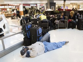 A man sleeps on the terminal floor at Hartfield-Jackson Atlanta International Airport, Monday, Dec. 18, 2017, in Atlanta. Power has been restored at the airport after a Sunday blackout caused by a fire stranded thousands of passengers and grounded at least 1,500 flights.