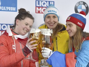 Canada's Elisabeth Vathje, left, celebrates her podium finish with race winner Jacqueline Loelling of Germany and third-place Elena Nikitina of Russia after their World Cup skeleton race in Winterberg, Germany on Friday, Dec. 8, 2017.