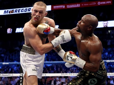 Floyd Mayweather (right) punches Conor McGregor during their super welterweight boxing match in Las Vegas on Aug. 26.