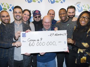 Lotto Max winners Julie Beland, Haidar Abi Haidar, Robert Macri, Diane Dorele Fossouo Djuidje, Nathaniel Thomas, Darius Hozhabr Zandi, Peter Jewett, Randolph Dandan and Enzo Scattone hold up a cheque for $60,000,000 in Montreal, Wednesday, December 27, 2017, after they won the jackpot on Friday, December 22 in Montreal.