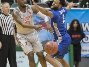 Miami guard Ja'Quan Newton (0) passes off the basketball while being defended by Middle Tennessee guard Antwain Johnson (2) during the first half of an NCAA college basketball game at the Diamond Head Classic, Monday, Dec. 25, 2017, in Honolulu.