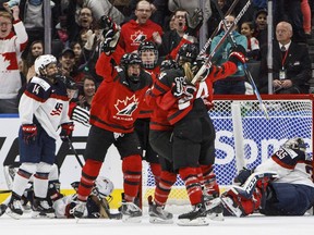 Canadian players celebrate the game-winning overtime goal against the United States during in the final game of the exhibition series between the two teams in Edmonton on Sunday, Dec. 17, 2017.