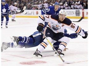 Edmonton Oilers centre Connor McDavid drives to the net past sprawling Toronto Maple Leafs defenceman Ron Hainsey on Dec. 10.