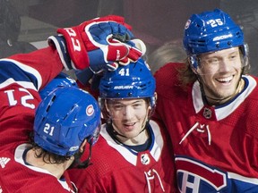 Canadiens' Paul Byron, centre, celebrates with teammates David Schlemko, left, and Jacob De La Rose after scoring against the Detroit Red Wings in Montreal on Saturday, Dec. 2, 2017.