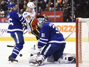 Maple Leafs goalie Frederik Andersen makes a save as Toronto defenceman Roman Polak and the Flames' Micheal Ferland battle during third period action in Toronto on Wednesday night.