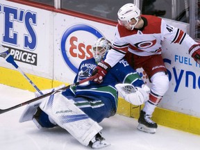 Carolina Hurricanes' Joakim Nordstrom knocks down Canucks goalie Jacob Markstrom during first period action in Vancouver on Tuesday night.