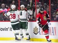 Minnesota Wild's Chris Stewart, centre, and Nate Prosser celebrate a goal as Ottawa Senators' Erik Karlsson skates past during the second period in Ottawa on Tuesday.