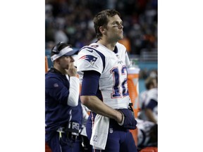 New England Patriots quarterback Tom Brady (12) watches the game from the sidelines, during the second half of an NFL football game against the Miami Dolphins, Monday, Dec. 11, 2017, in Miami Gardens, Fla.