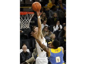 Iowa forward Jack Nunge, left, blocks a shot by Southern University guard Richard Lee (0) during the first half of an NCAA college basketball game, Sunday, Dec. 10, 2017, in Iowa City, Iowa.