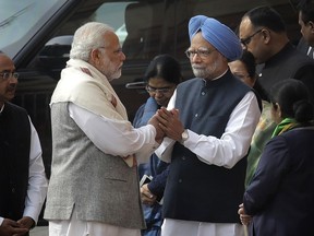 FILE - In this Wednesday, Dec. 13, 2017, file photo, Indian Prime Minister Narendra Modi, left, holds hands with his former counterpart Manmohan Singh during a ceremony to pay tributes to security officials who lost their lives in the 2001 attack on Indian parliament, in New Delhi, India. Against the backdrop of an increasingly personal and bitterly fought local election, India is witnessing the unusual spectacle of Modi locked in a bitter verbal duel with his predecessor, accusing the opposition of holding secret meetings with officials from archrival Pakistan to impact the polls. The unsubstantiated allegations have prompted a sharply worded response from Singh.