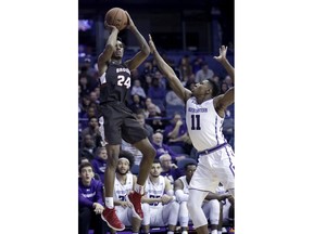 Brown guard Desmond Cambridge, left, shoots against Northwestern guard Anthony Gaines during the first half of an NCAA college basketball game, Saturday, Dec. 30, 2017, in Rosemont, Ill.