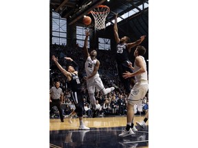 Butler forward Kelan Martin (30) shoots between Villanova defenders Donte DiVincenzo (10) and Mikal Bridges (25) in the first half of an NCAA college basketball game in Indianapolis, Saturday, Dec. 30, 2017.