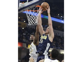 Denver Nuggets' Mason Plumlee puts up a shot against Indiana Pacers' Thaddeus Young during the first half of an NBA basketball game, Sunday, Dec. 10, 2017, in Indianapolis.