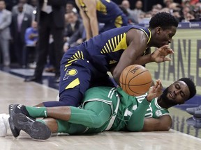 Indiana Pacers' Victor Oladipo, top, and Boston Celtics' Jaylen Brown battle for a loose ball during the first half of an NBA basketball game, Monday, Dec. 18, 2017, in Indianapolis.