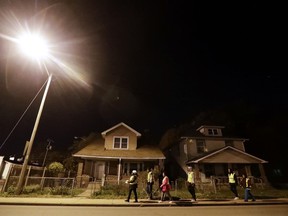 Members of the Ten Point Coalition talk a walk through a neighborhood, Wednesday, Nov. 8, 2017, in Indianapolis. The coalition walks neighborhoods to help reduce violence and homicide through direct contact.