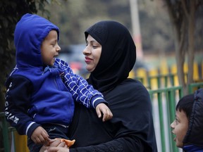 An Indian Muslim woman plays with her child as they stroll in a park in Allahabad, India, Thursday, Dec. 28, 2017. The government on Thursday introduced a new draft law for discussion and adoption by Parliament for banning the practice of ''triple talaq'' and suggesting three years' imprisonment for an offender.