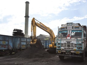 In this July 14, 2017 photo, domestically produced petroleum coke is loaded onto a truck to be transported to factories, at a railway station in Rampur, about 210 kilometers (130 miles) from New Delhi, India. Petcoke is the black, bottom-of-the-barrel oil-refining waste that containing more sulfur than what's allowed in coal. Within a decade, India's petcoke appetite grew so voracious that it began producing and selling its own, and Indian refineries today are making about as much as the country is importing. (AP Photo/Vaishnavee Sharma)