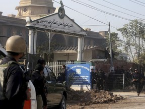 Pakistani troops take position, outside the agriculture institute stormed by militants in Peshawar, Pakistan, Friday, Dec. 1, 2017. Pakistani police say gunmen have stormed a government complex in the northwestern city of Peshawar, killing an unconfirmed number of people. (AP Photo/Muhammad Sajjad)