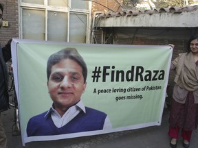 Colleagues of Pakistan's missing human rights activist Raza Mahmood hold a banner demanding his whereabouts, in Lahore, Pakistan, Friday, Dec. 8, 2017. A Pakistani human rights activist who has campaigned for friendly ties with India has gone missing in the eastern city of Lahore.