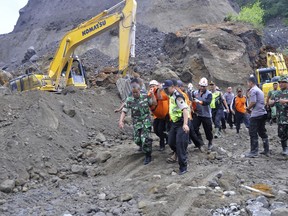 Rescuers carry the body of a landslide victim in Magelang, Central Java, Indonesia, Monday, Dec. 18, 2017. Disaster officials say a number of people have been found dead after being buried in a landslide while excavating a sand pit on Indonesia's main island of Java. (AP Photo)