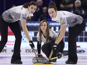 Skip Rachel Homan of Ottawa, Ont. looks down the sheet as lead Lisa Weagle, left, and second Joanne Courtney sweep in front of her rock during the women's semifinal draw against Team Jones at the 2017 Roar of the Rings Canadian Olympic Trials in Ottawa on Saturday, Dec. 9, 2017.