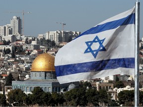 The Israeli flag flutters in front of the Dome of the Rock mosque and the city of Jerusalem, on December 1, 2017.   Shifting the building could be seen as a de facto recognition of Israel's claim over the whole city, including predominantly Palestinian east Jerusalem.