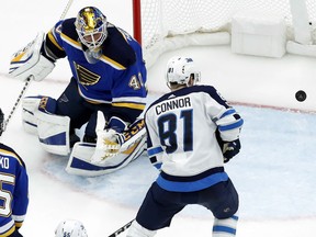 Winnipeg Jets' Kyle Connor and Blues goalie Carter Hutton watch the puck during the second period of their game Saturday night in St. Louis.