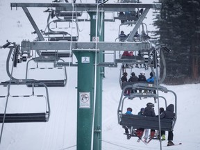 Skiers wait on the chair lift after a power failure shut down all operations at the women's World Cup downhill ski race at Lake Louise, Alta., Saturday, Dec. 2, 2017.
