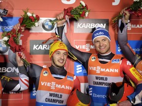 Germany's Toni Eggert, right, and Sascha Benecken celebrates their victory in the doubles World Cup luge competition in Calgary, Friday, Dec. 8, 2017.